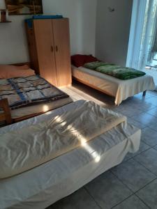 a bedroom with two beds and a dresser in it at Badacsonyi Panorámás magánszállás in Badacsonytomaj