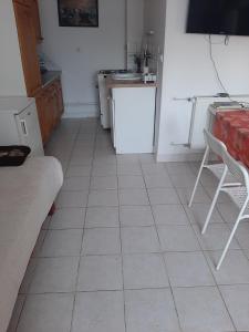 a kitchen with a white tiled floor and a white refrigerator at Badacsonyi Panorámás magánszállás in Badacsonytomaj