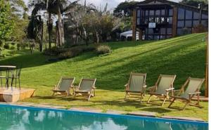 - un groupe de chaises longues à côté de la piscine dans l'établissement POUSADA PARAISO DOS TUCANOS, à Aiuruoca