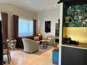 - un salon avec un canapé et une table dans l'établissement Chalet Maurice, à Zutendaal