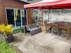 patio con tavolo, sedie e ombrellone di Odelil a Le Guillaume