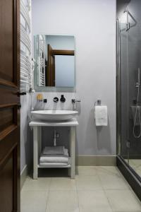 a bathroom with a sink and a mirror and a shower at Alma Boutique Hotel in Tbilisi City