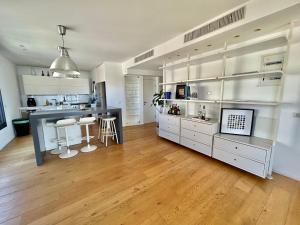 uma grande cozinha com armários brancos e piso em madeira em Beautiful 2BR In Ramat Gan em Ramat Gan