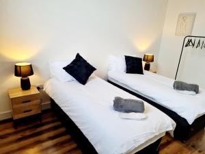 two twin beds in a room with two lamps at Burkhardt Hall- Parking Included- Sleeps 4 in Swindon