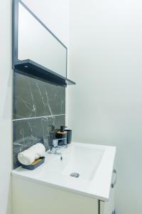 a bathroom with a white sink and a mirror at L'ELEDAURAT - Centre ville Riom - Idéal professionnel - Proche Clermont Ferrand in Riom +28 photos