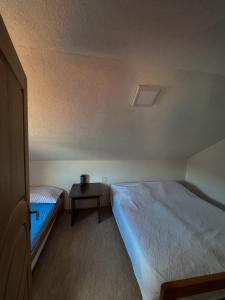 a room with a bed and a night stand with a table at Edison in Jablanica