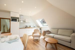 a living room with a couch and a table at Duplex Petit-Fort proche plage in Gravelines +14 photos
