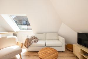 a living room with a couch and a tv at Duplex Petit-Fort proche plage in Gravelines