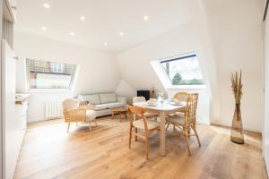 a living room with a table and chairs and a couch at Duplex Petit-Fort proche plage in Gravelines
