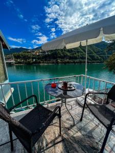 a table and chairs on a balcony with a view of a lake at Edison in Jablanica +9 photos