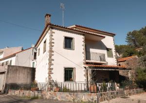 a white house with a fence in front of it at Casa Penafalcão in Castelo Branco