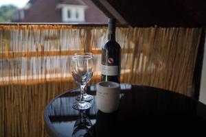 una botella de vino y una copa de vino en una mesa en "SANO" Apartments - Herdecke - Maisonette - Balkon - Tiefgarage en Herdecke