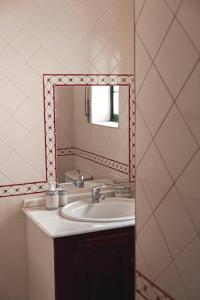 La salle de bains est pourvue d'un lavabo et d'un miroir. dans l'établissement Casa Penafalcão, à Castelo Branco