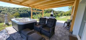 zwei Stühle neben einer Badewanne auf einer Terrasse in der Unterkunft Villa Hojnik in Videm pri Ptuju
