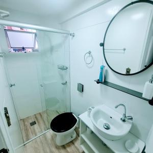 bagno con lavandino, servizi igienici e specchio di Flat Jardim Botânico Curitiba até 7 pessoas a Curitiba