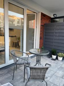 een patio met een tafel en 2 stoelen en een tafel bij Apartament Poezji A39 Grey in Gliwice