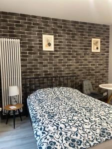 een slaapkamer met een bed en een bakstenen muur bij Apartament Poezji A39 Grey in Gliwice