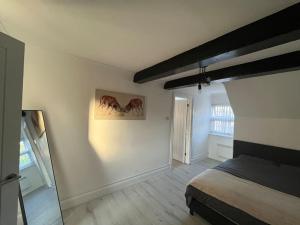 a bedroom with a bed and a painting on the wall at Stylish 1 Bedroom Apartment - City Centre and Close to Airport in Luton