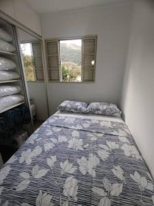 - une chambre avec un lit et une couette bleue et blanche dans l'établissement Apartamento Frente da Praça Central com 01 Vaga Garagem, à Poços de Caldas