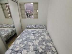 - une chambre avec 2 lits et 2 fenêtres dans l'établissement Apartamento Frente da Praça Central com 01 Vaga Garagem, à Poços de Caldas
