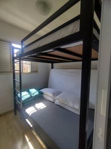 - une chambre avec 2 lits superposés et des draps blancs dans l'établissement Apartamento Frente da Praça Central com 01 Vaga Garagem, à Poços de Caldas