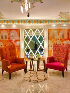 a room with two chairs and a table and a window at Hotel Sarang Palace - Boutique Stays in Jaipur