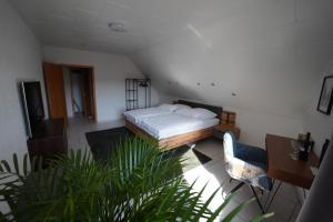 a bedroom with a bed and a table and a chair at SANO Apartments - Bei Volkmar in Herdecke