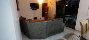 un sofá de cuero en una sala de estar con TV en Casa libella, en Carmen de Apicalá