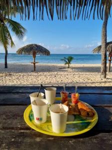 - une assiette de nourriture accompagnée de boissons sur la plage dans l'établissement Studio Coco Passion, à Saint-François