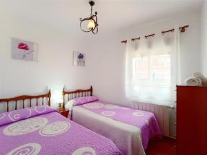CASA RASPA, BATERNA (ÁVILA) في Baterna: سريرين في غرفة ذات أغطية أرجوانية