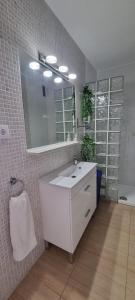 uma casa de banho com um lavatório branco e um espelho. em Peñismar 50 em Peníscola
