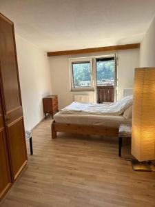 een slaapkamer met een bed en 2 ramen bij Geräumige rustikale Tiroler Wohnung 1-8 Personen in Imst
