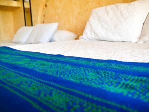 ein Bett mit einer blauen und weißen Decke drauf in der Unterkunft Villa DALIJÚ in Santa María Huatulco