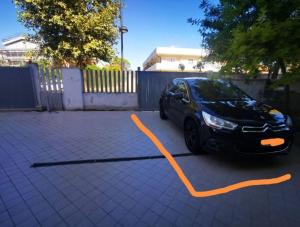 a car parked in a parking lot with an orange hose at Appartamento da Paola in Pescara