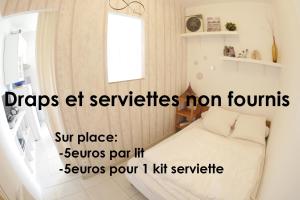 a small bedroom with a bed and a window at Le Porge Beach House - 4 people in Le Porge
