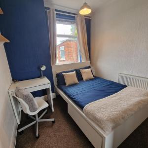a bedroom with a bed and a desk and a chair at Double room in Heaton in Heaton