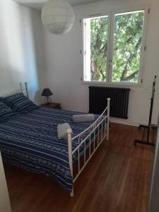 a bedroom with a bed and a large window at Maison au Calme, prés du centre Parking Privé in Angoulême +2 photos