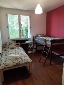 a room with two beds and a chair and a window at Maison au Calme, prés du centre Parking Privé in Angoulême