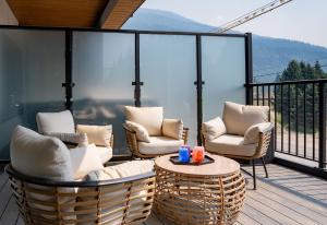 a balcony with chairs and a table with a view at Galena by Revelstoke Vacations in Revelstoke
