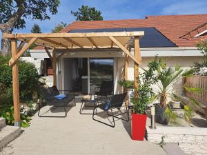 a wooden pergola with chairs and a table at Adorelys week end massage et spa in Saint-Cassien