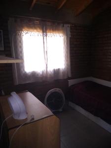 um quarto com uma janela e uma secretária com uma ventoinha em La Lechuza em El Volcán