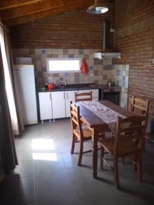 La Lechuza في إلفولكان: مطبخ مع طاولة وكراسي خشبية وثلاجة