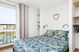 - une chambre avec un lit et une grande fenêtre dans l'établissement Fare Laurent, à Saint-Cyprien