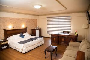 1 dormitorio con 1 cama grande y 1 sofá en AVANTI HOTEL & CONVENTION CENTER, en Cochabamba
