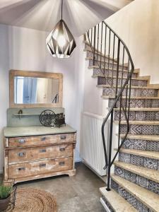 a staircase in a room with a dresser and a mirror at NUMMER EiNS in Neuötting