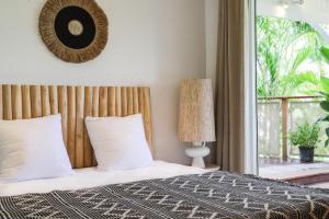 a bedroom with a bed with white pillows and a window at Kirsty's Place in Saint Barthelemy