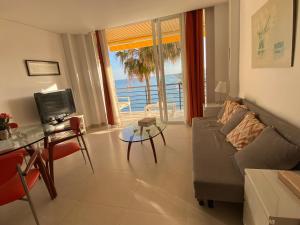een woonkamer met een bank en uitzicht op de oceaan bij Castillo Santa Clara in Torremolinos