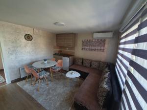 uma sala de estar com um sofá, uma mesa e cadeiras em Apartman Nikolina em Bajina Bašta