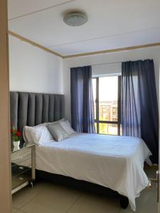 a bedroom with a bed with a large window at Siena Sun Luxury Apartment 6 in Midrand