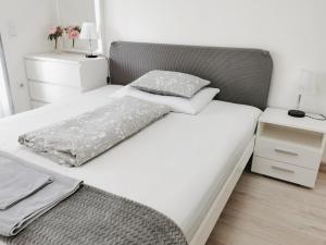 een wit bed met twee kussens erop bij Ani's Home newly built apartment in Boedapest